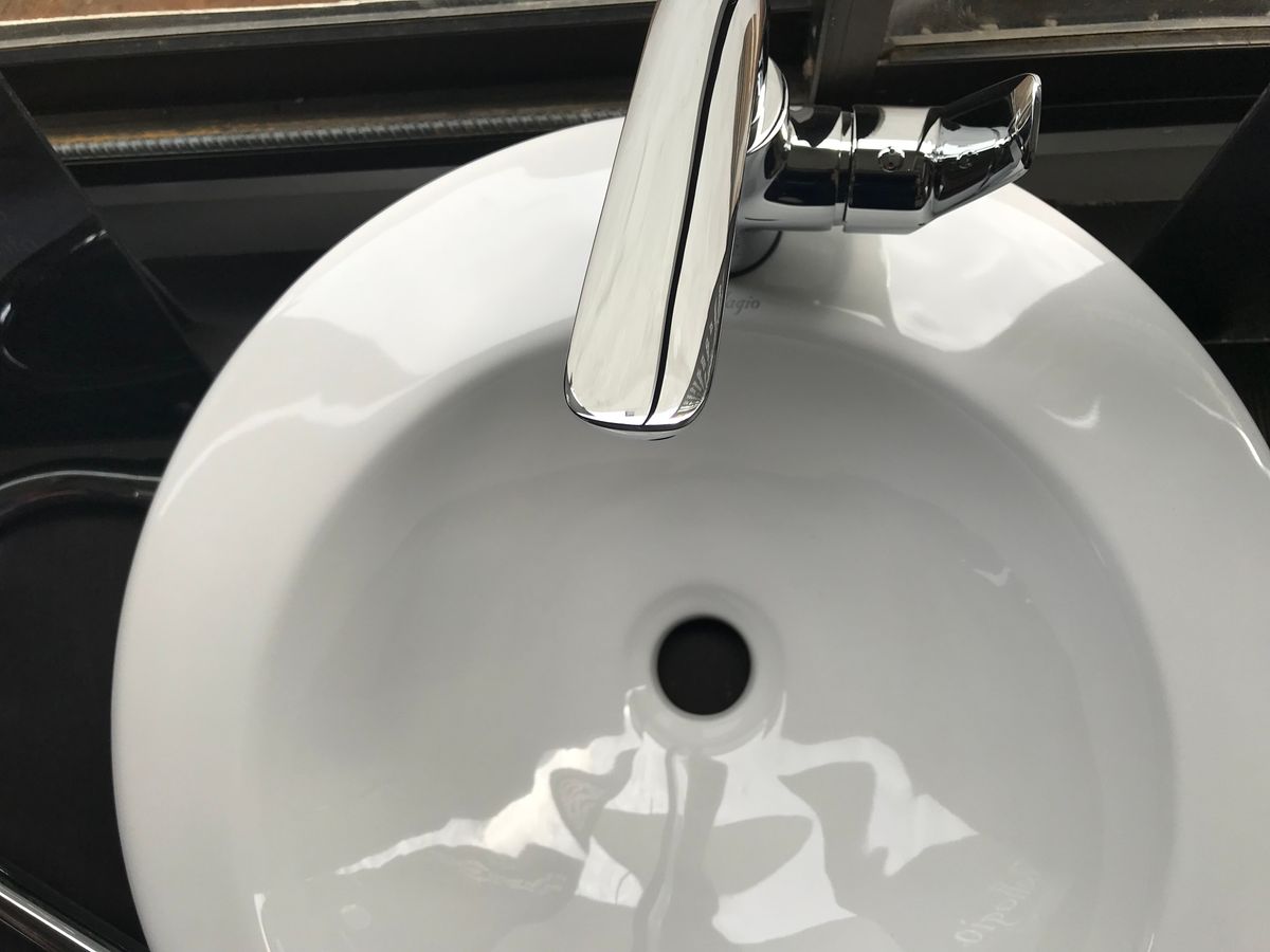 A clean white bathroom sink with a chrome faucet