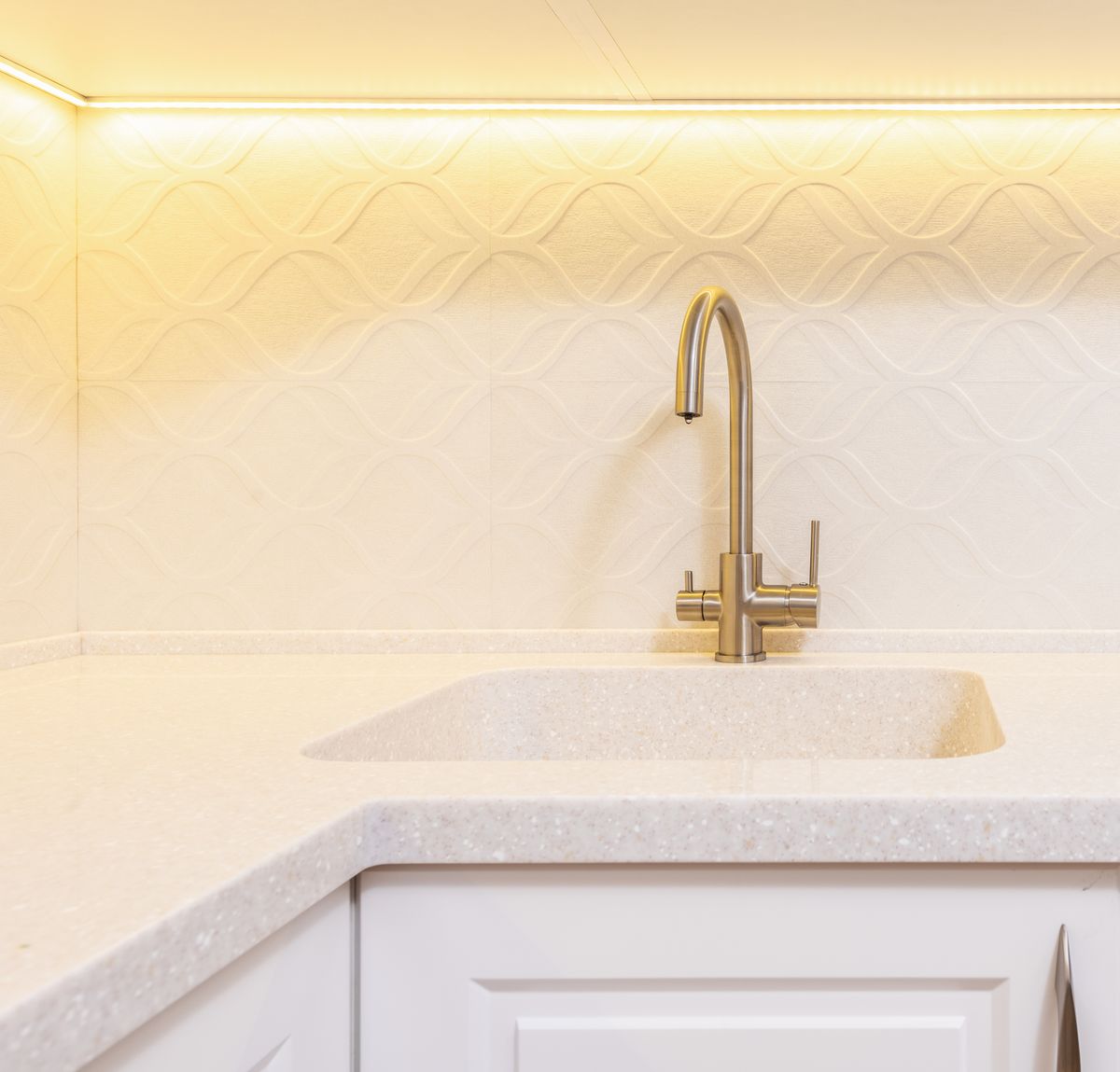A bright kitchen sink with a tall gooseneck faucet