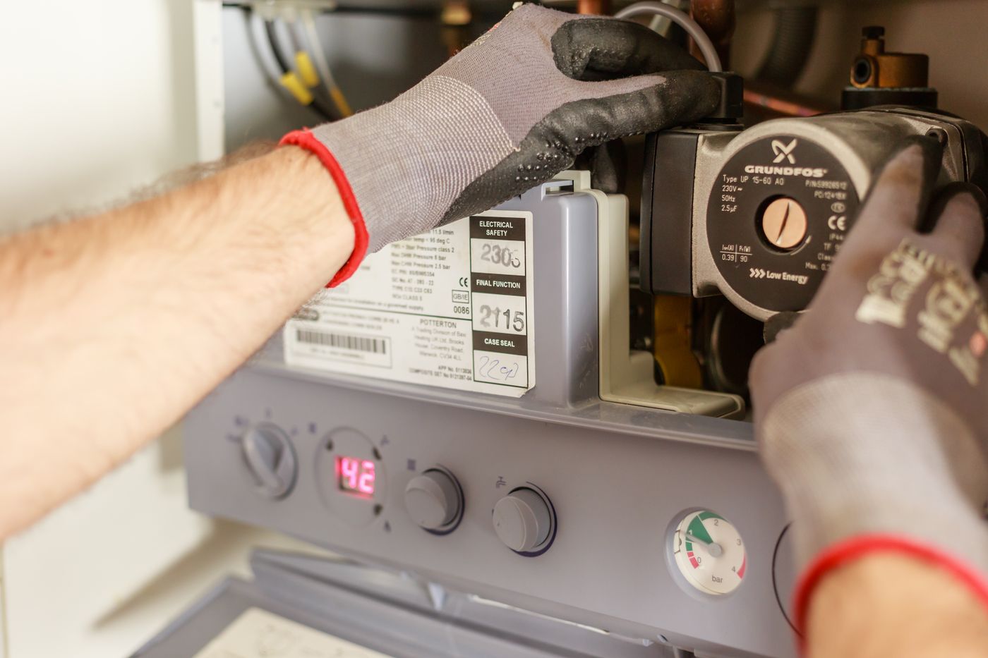A technician servicing a heating and hot water unit