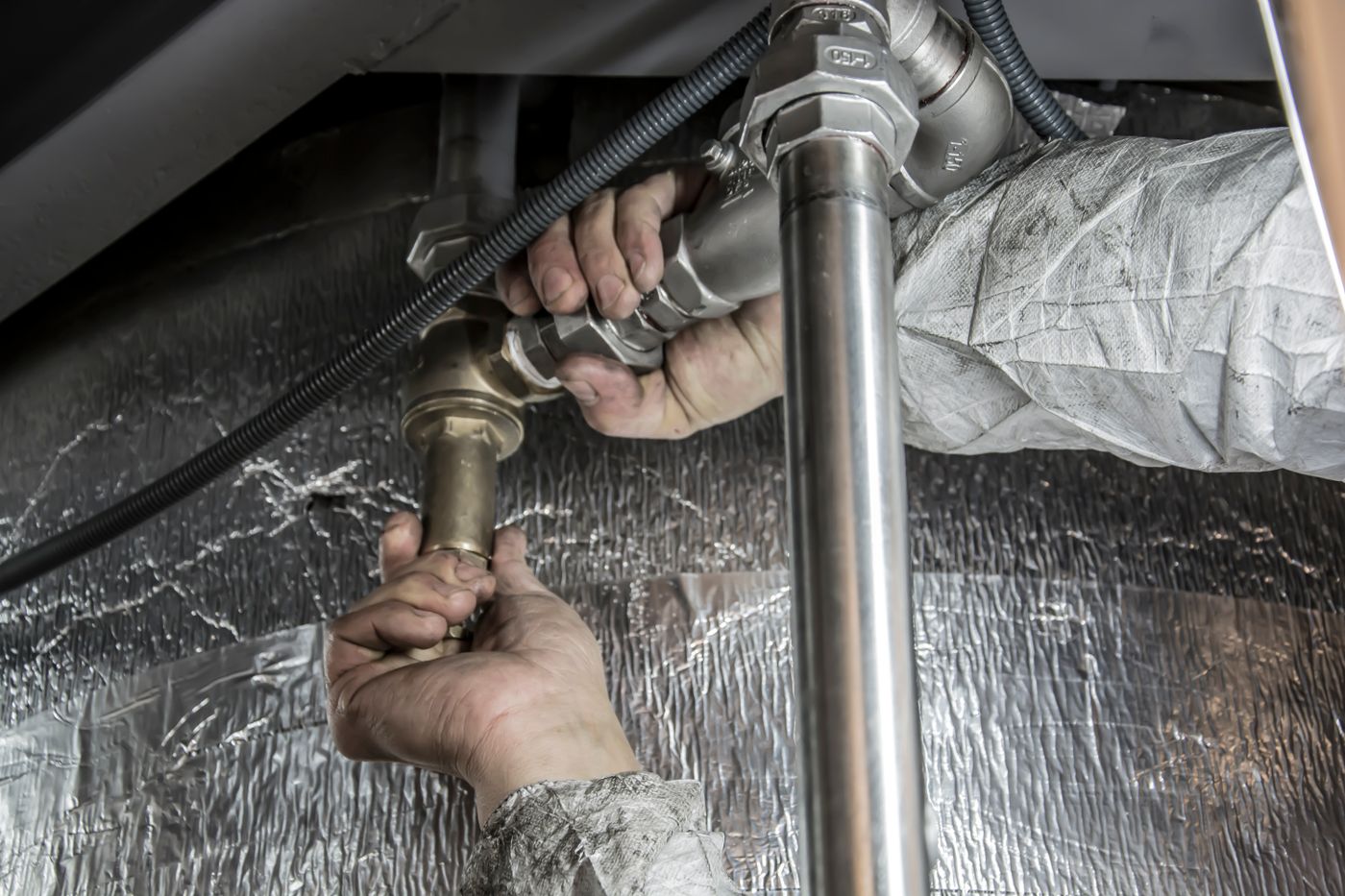 Hands installing large water line pipe fittings
